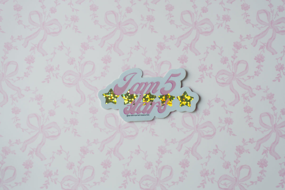 A die-cut sticker featuring the text 'I am 5 stars' in pink cursive with five yellow glittery stars, shown on a light pink floral and bow patterned background.