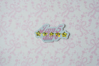 A die-cut sticker featuring the text 'I am 5 stars' in pink cursive with five yellow glittery stars, shown on a light pink floral and bow patterned background.
