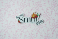A die-cut sticker with the text 'In my Smut era' and chili pepper illustrations, displayed on a light pink patterned background.