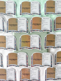 A repeating pattern of book-shaped table toasts or placemats with the title 'evermore' and a list of words, shown on a pale mint background.