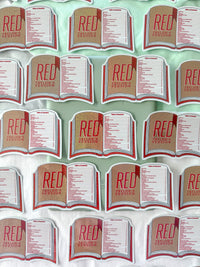 A repeating pattern of small book-shaped stickers or labels reading "RED" and "Taylor's Version" arranged on a pale mint background.